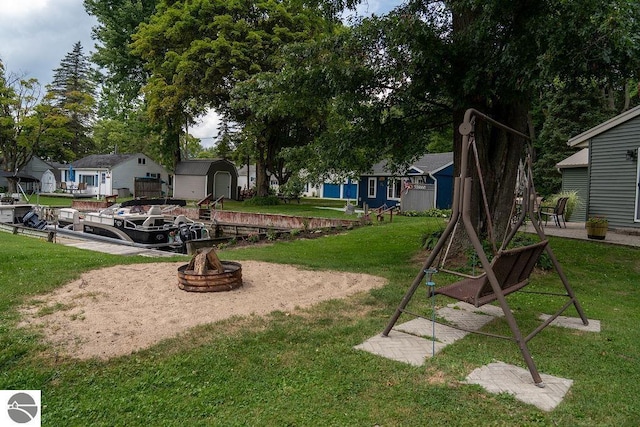 view of yard featuring a fire pit and a storage unit