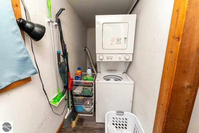 laundry room featuring stacked washer / dryer and dark hardwood / wood-style flooring