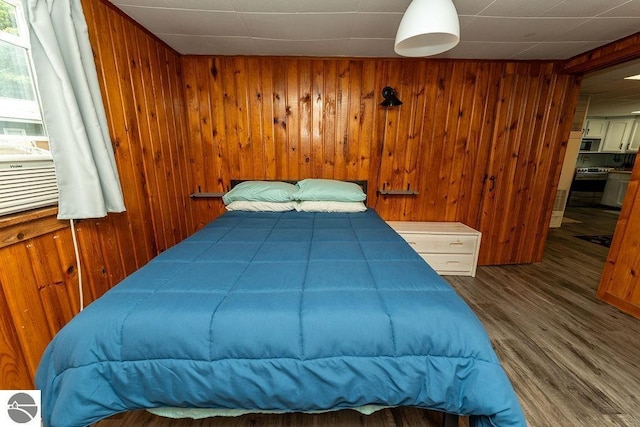 bedroom featuring hardwood / wood-style flooring and wooden walls