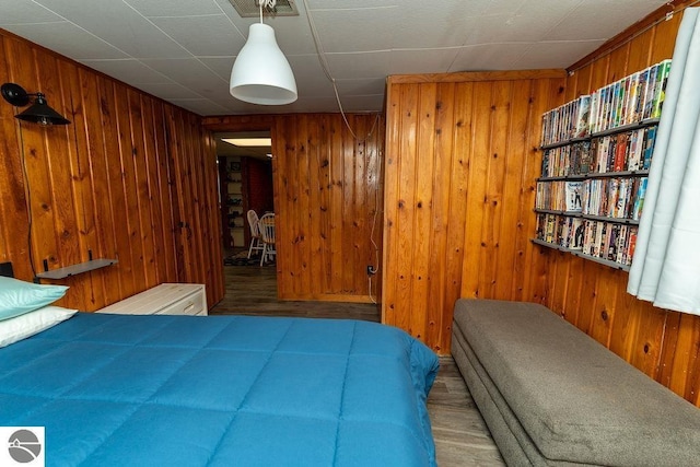 bedroom with wooden walls and wood-type flooring