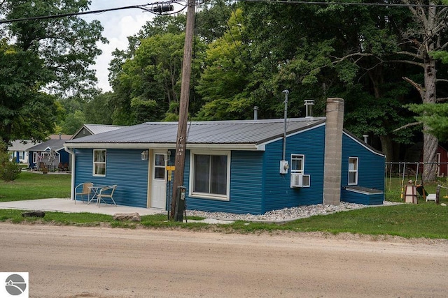 view of front facade featuring cooling unit, a front lawn, and a patio