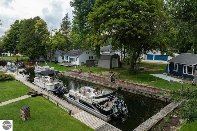 view of dock with a water view and a lawn