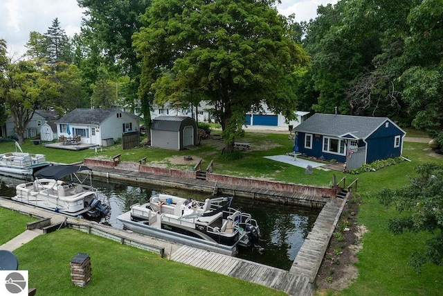 view of dock with a deck with water view and a lawn