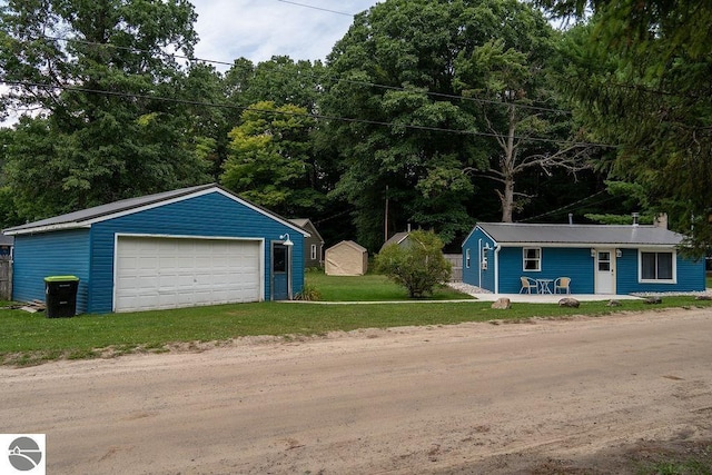 view of front of home featuring a garage, an outdoor structure, and a front yard