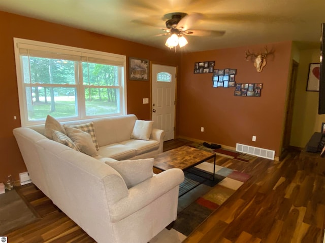 living room with dark hardwood / wood-style flooring and ceiling fan