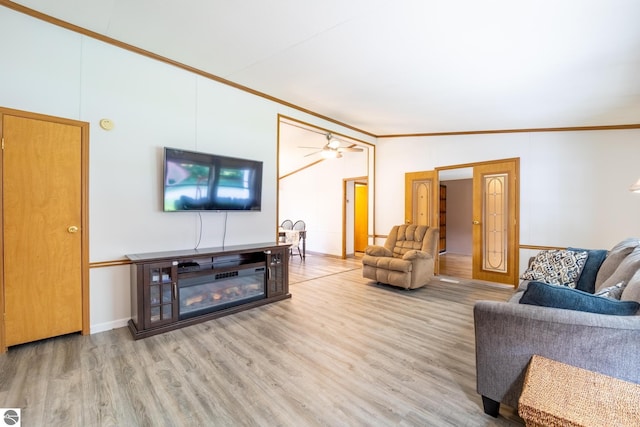 living room with ornamental molding, light hardwood / wood-style flooring, lofted ceiling, and ceiling fan