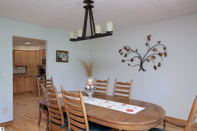 dining area featuring a notable chandelier and light wood-type flooring