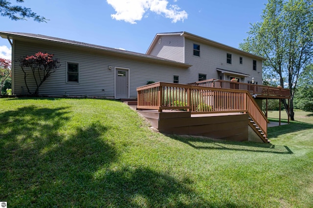 rear view of property with a wooden deck and a yard