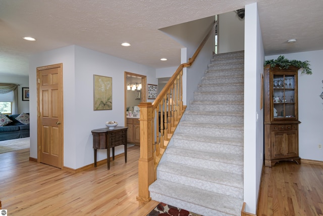 staircase featuring wood-type flooring and a textured ceiling