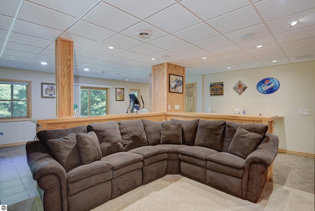 living room featuring a paneled ceiling and tile patterned floors