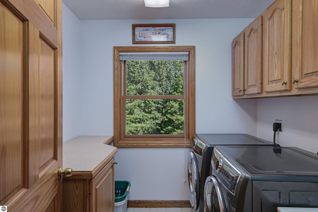 clothes washing area with cabinets and separate washer and dryer