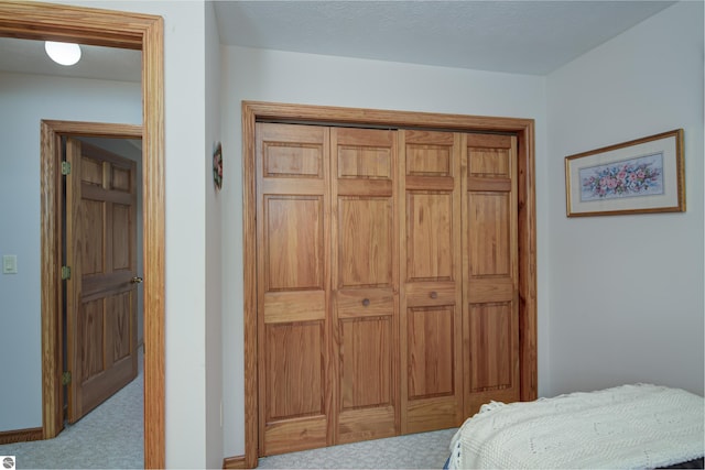 bedroom featuring a closet and light carpet