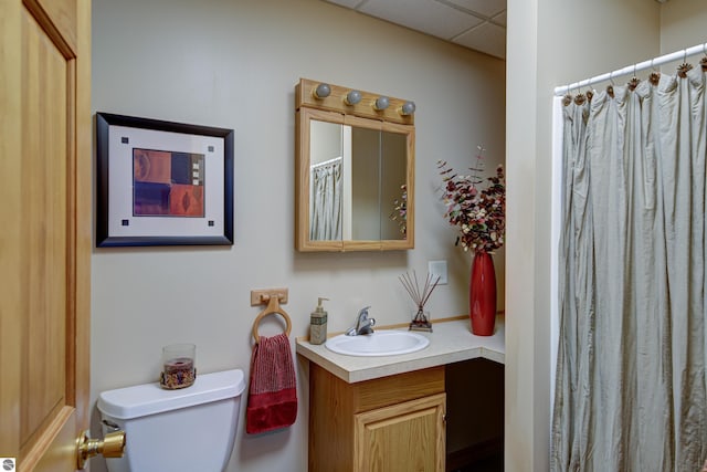 bathroom featuring vanity, a shower with shower curtain, a drop ceiling, and toilet