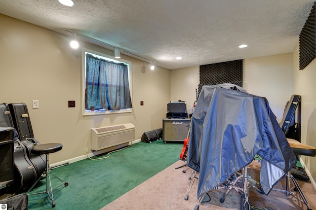 miscellaneous room featuring track lighting, carpet, a wall unit AC, and a textured ceiling