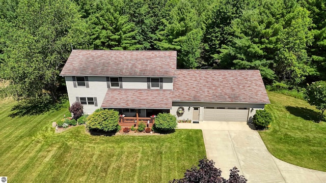 view of front of house with a garage, a porch, and a front lawn