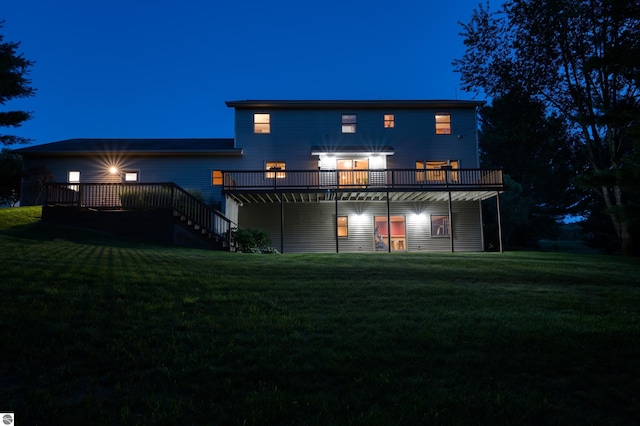 back house at twilight featuring a wooden deck and a yard