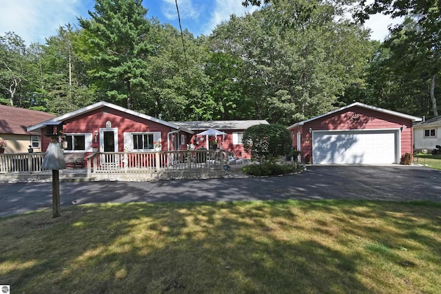 single story home with a garage, a deck, and a front lawn