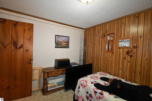 carpeted bedroom with crown molding, a textured ceiling, and wood walls