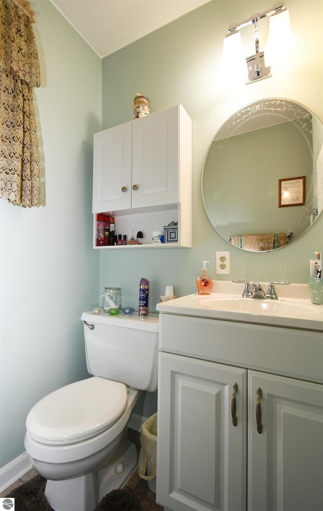 bathroom featuring vanity, a textured ceiling, and toilet