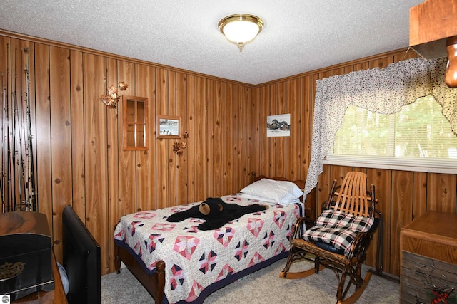 bedroom with ornamental molding, carpet floors, a textured ceiling, and wood walls