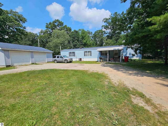 view of front of home with a garage, a front lawn, and an outbuilding