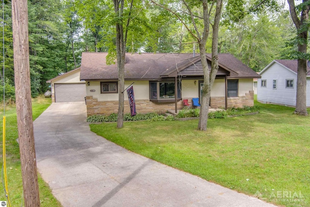 ranch-style home with a shingled roof, a front yard, stone siding, and a garage