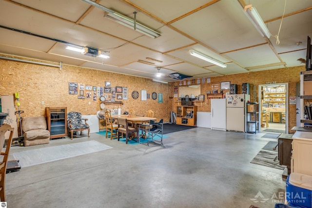 garage with a garage door opener and freestanding refrigerator