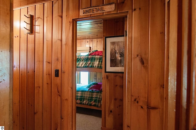 carpeted bedroom with wood walls