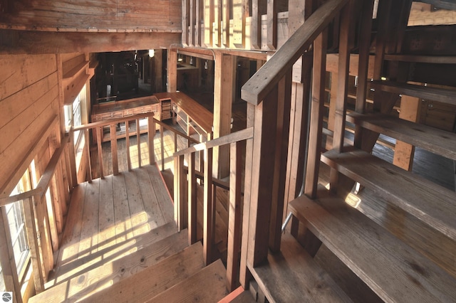 staircase featuring wood walls