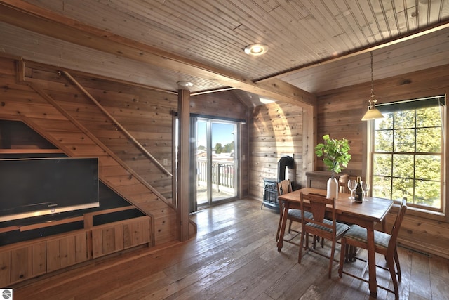 dining area with wood ceiling, a wood stove, wooden walls, and hardwood / wood-style floors