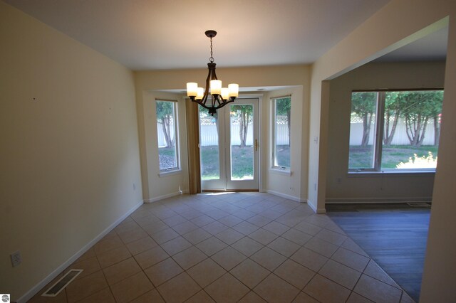 unfurnished room featuring hardwood / wood-style flooring and a chandelier