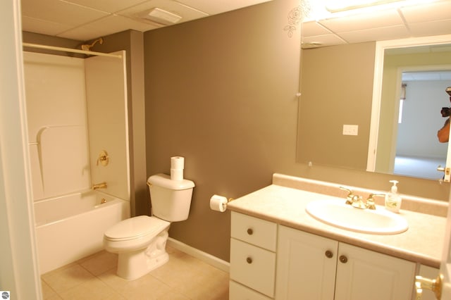 full bathroom featuring toilet, a paneled ceiling, tile patterned flooring,  shower combination, and vanity