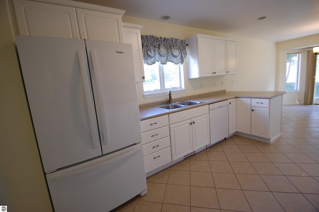 kitchen with white appliances, a wealth of natural light, white cabinets, and kitchen peninsula