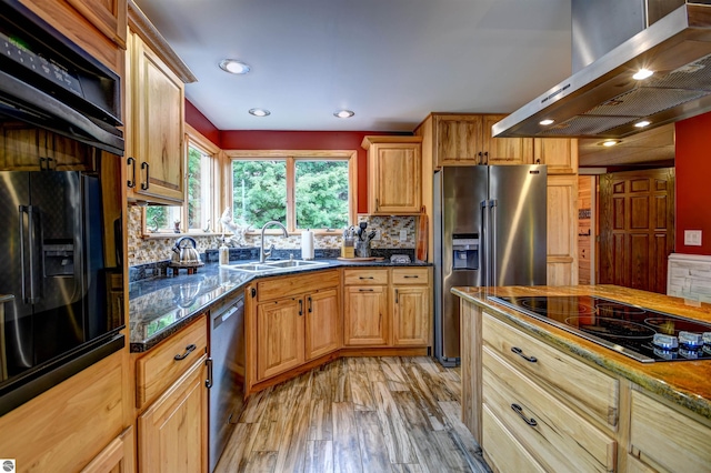 kitchen with sink, tasteful backsplash, light wood-type flooring, range hood, and black appliances