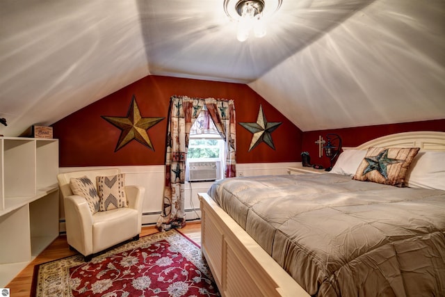 bedroom featuring cooling unit, a baseboard heating unit, vaulted ceiling, and light hardwood / wood-style floors