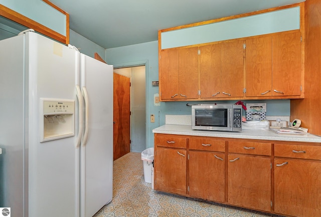 kitchen featuring white refrigerator with ice dispenser and light tile patterned floors