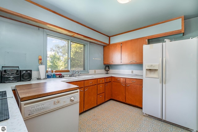 kitchen with crown molding, sink, white appliances, and light tile patterned floors