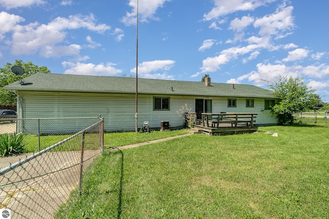 rear view of property with a deck and a lawn