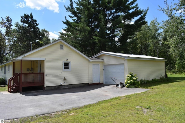 view of front facade featuring a garage, metal roof, driveway, and a front lawn