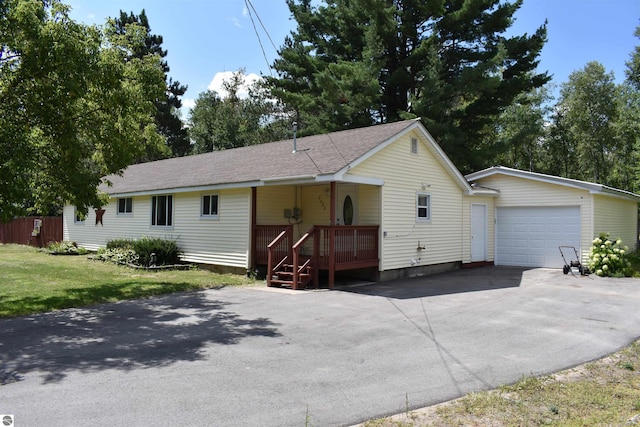 ranch-style home featuring driveway, a shingled roof, and a front lawn