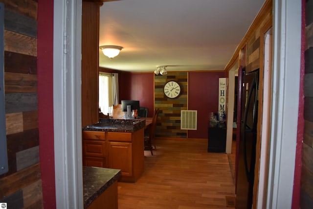 interior space with light wood finished floors, visible vents, and ornamental molding