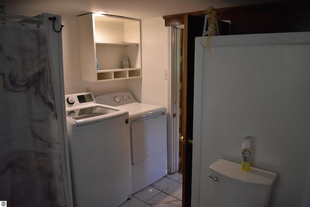 laundry area featuring marble finish floor, washing machine and dryer, and laundry area