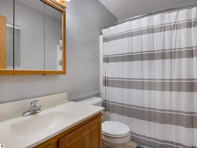 bathroom featuring a textured ceiling, toilet, and vanity