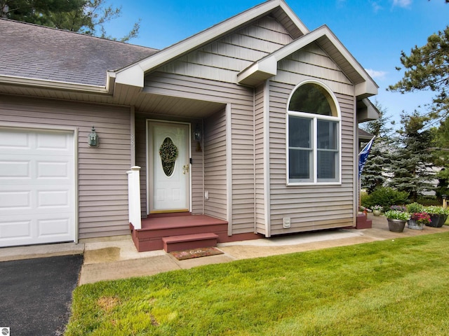 doorway to property featuring a garage and a yard