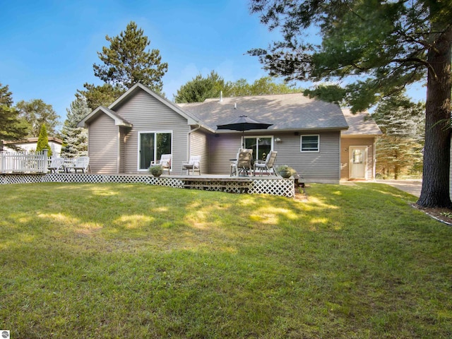 ranch-style home featuring a deck and a front lawn