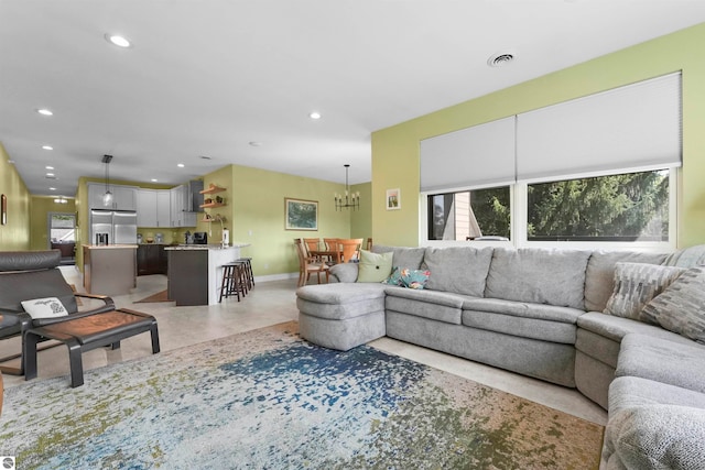 living room with light tile patterned floors and an inviting chandelier