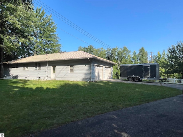 view of side of property featuring a garage and a lawn