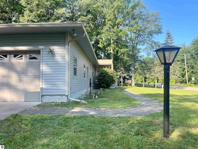 view of property exterior featuring a yard and a garage