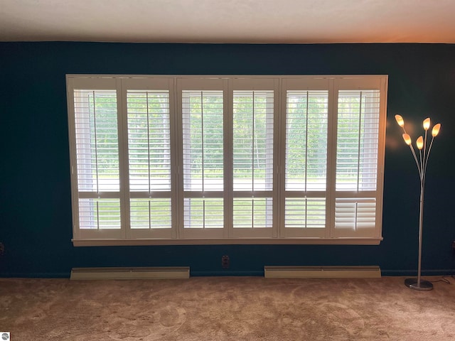 carpeted spare room featuring baseboard heating