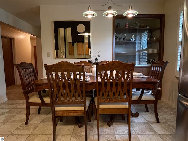 dining area with light tile patterned flooring and a chandelier